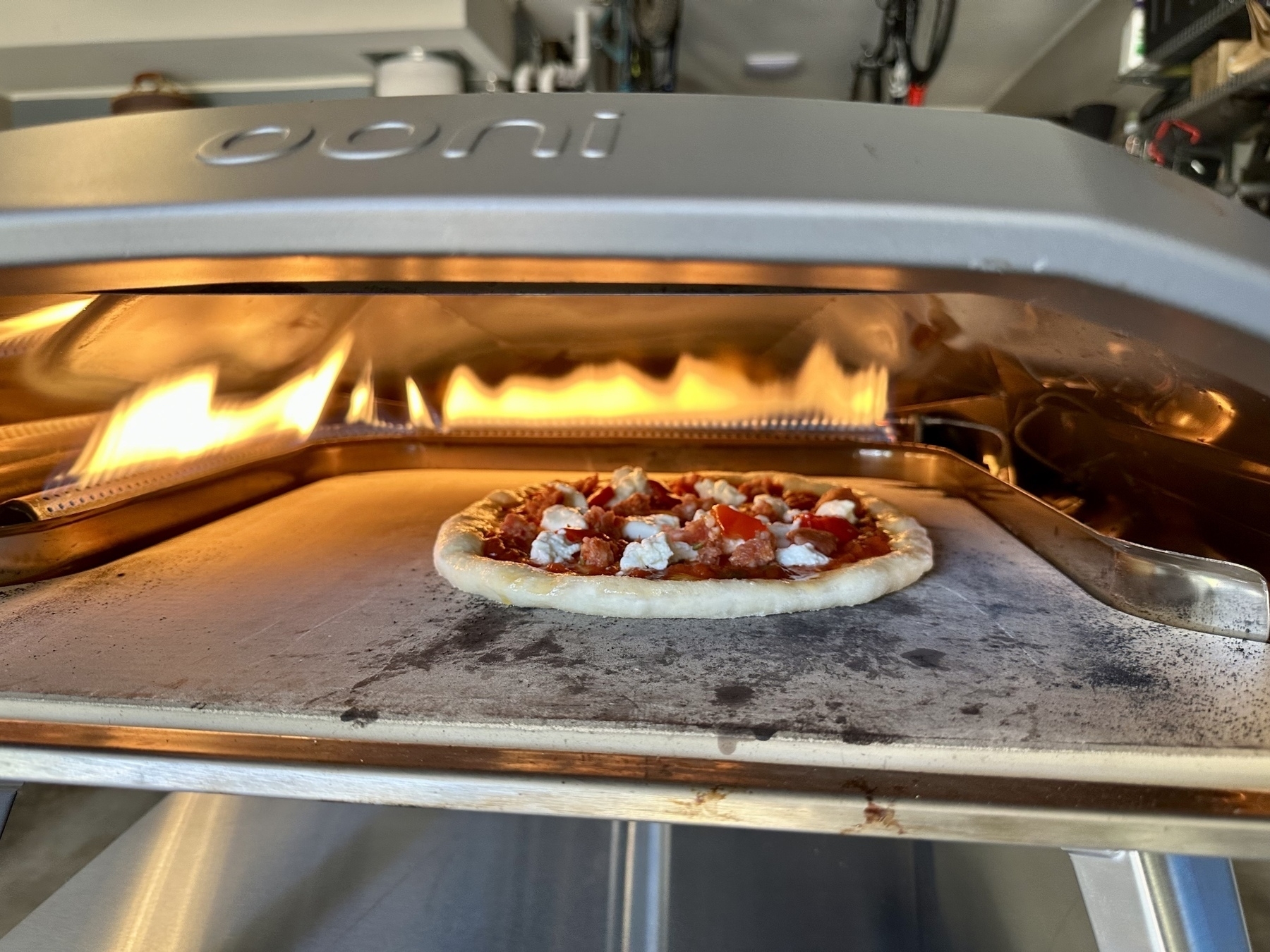 Pizza cooking in an Ooni pizza oven.